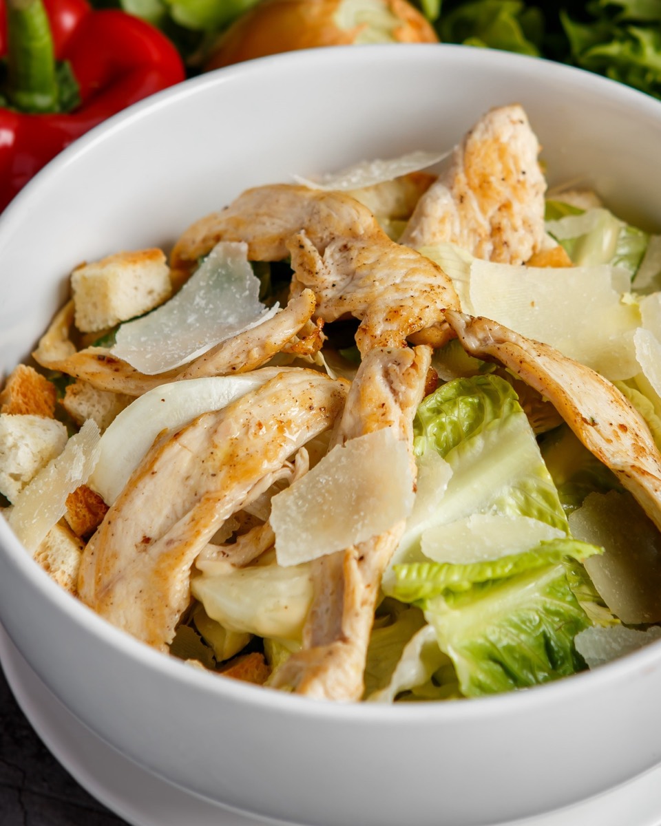 Italian bowl with grilled chicken, parmesan, croutons and romaine in a white bowl